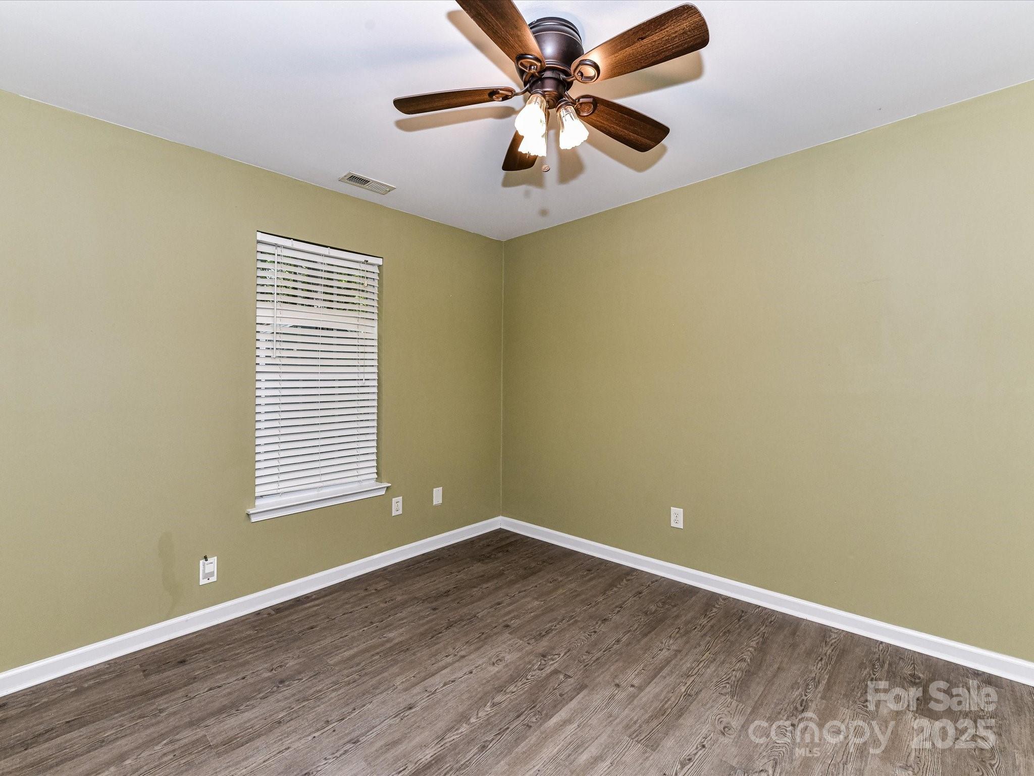 12224 Lullingstone Road Pineville, NC 28134 - Photo 17 of 26 an empty room with a window and a fan