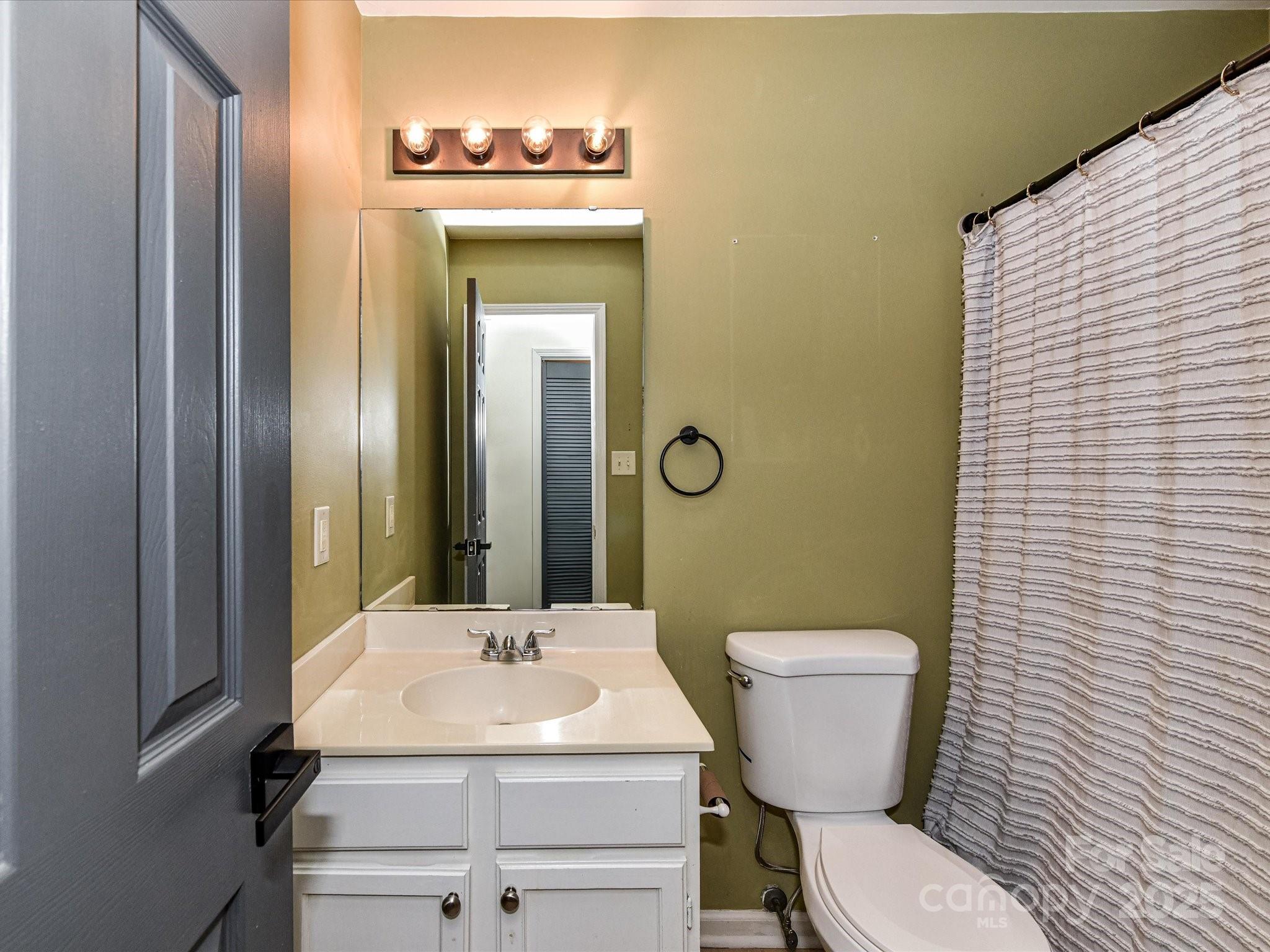 12224 Lullingstone Road Pineville, NC 28134 - Photo 19 of 26 a bathroom with a toilet a sink and mirror