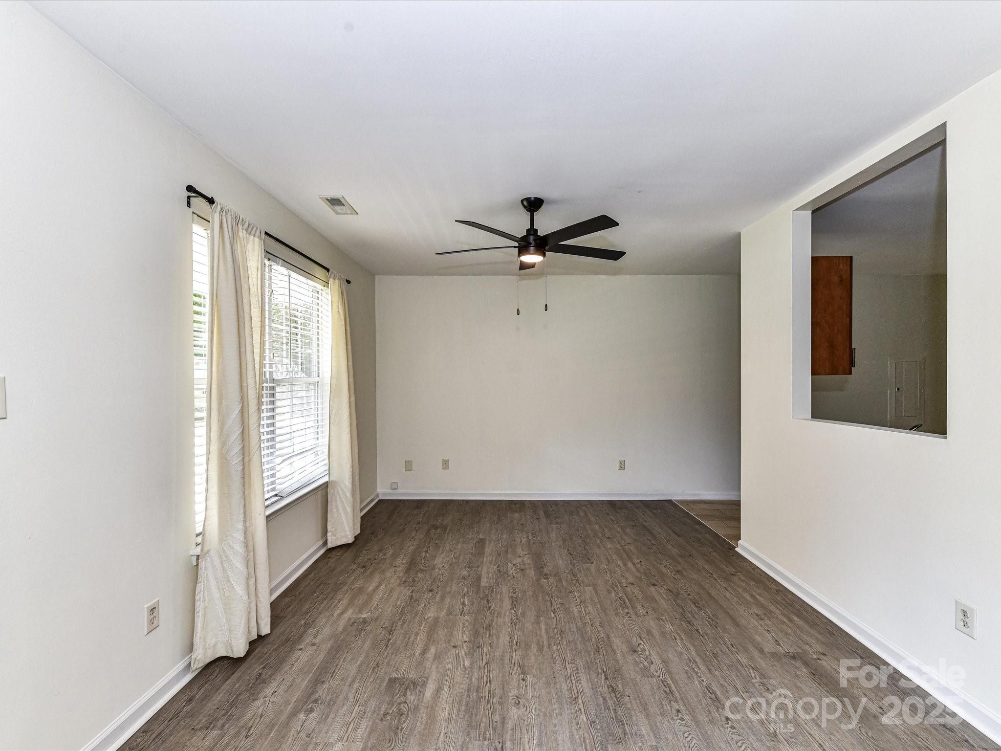 12224 Lullingstone Road Pineville, NC 28134 - Photo 6 of 26 an empty room with wooden floor fan and windows
