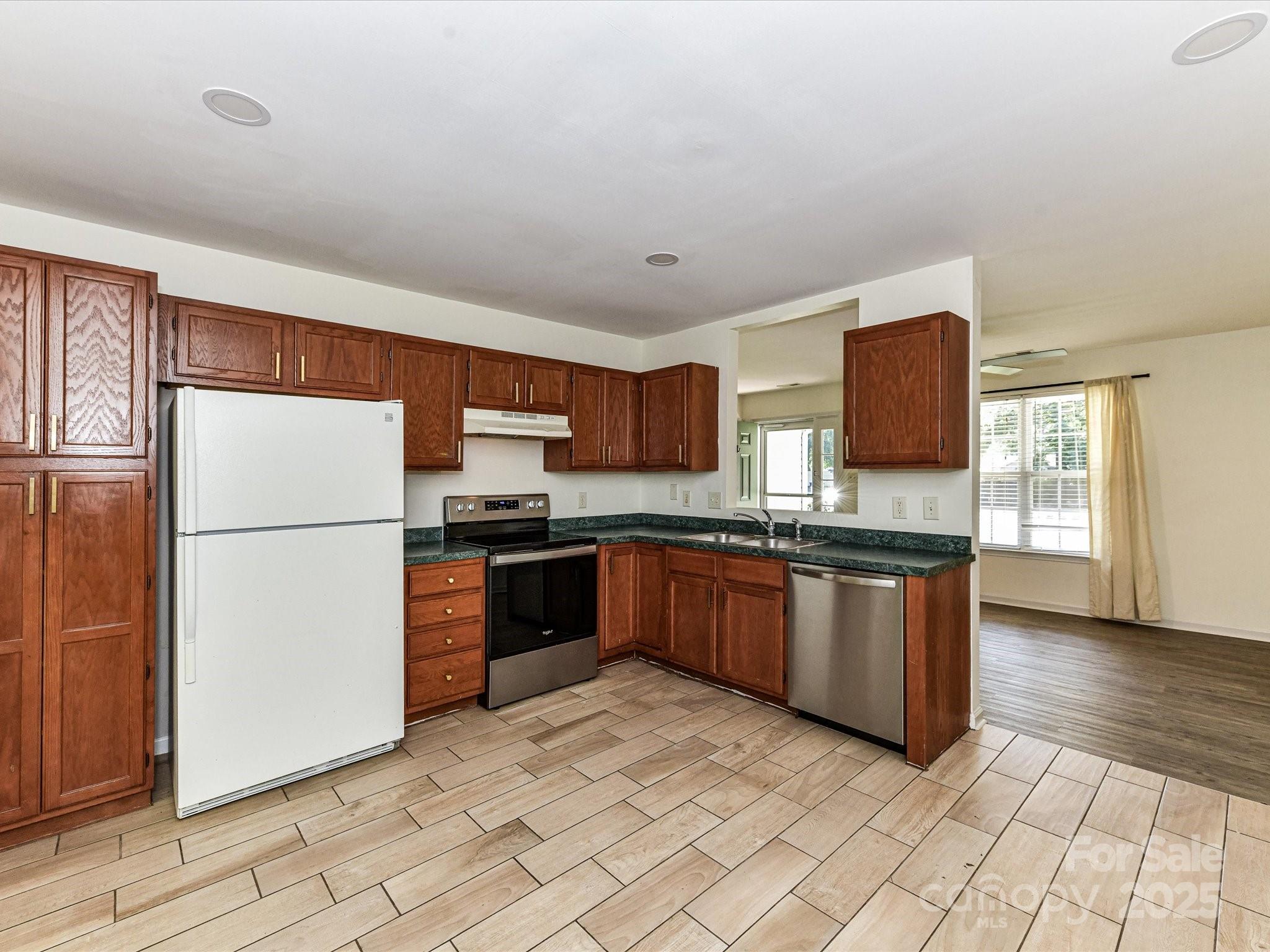 12224 Lullingstone Road Pineville, NC 28134 - Photo 8 of 26 a kitchen with stainless steel appliances granite countertop a refrigerator stove top oven and sink