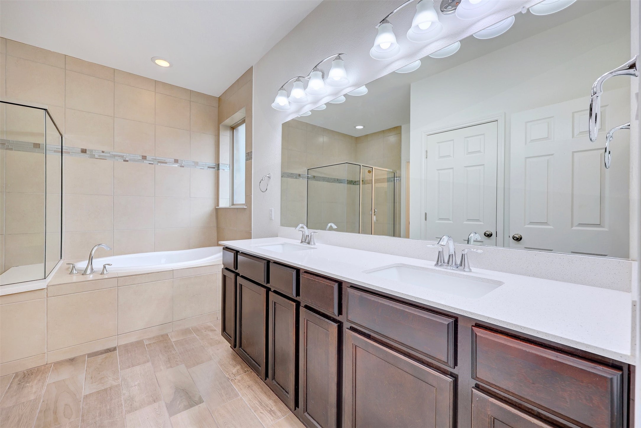 307 Simmental Loop Hutto, TX 78634 - Photo 18 of 34 Indulge in a tranquil retreat featuring a deep soaking tub and dual vanities, perfect for unwinding.