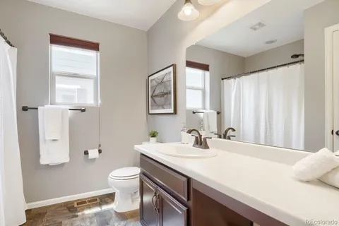 a bathroom with a sink a toilet and a large mirror