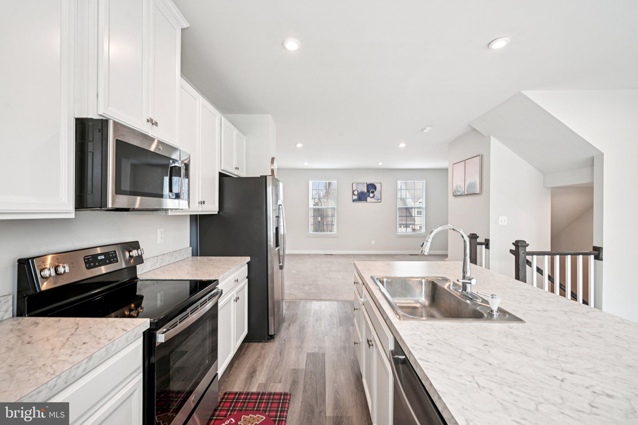 2055 Rivers Drive Newark, DE 19702 - Photo 11 of 32 a large kitchen with stainless steel appliances granite countertop a lot of counter space a sink and dishwasher a stove top oven with wooden floor