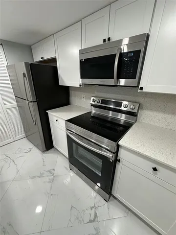 a stove top oven sitting inside of a kitchen