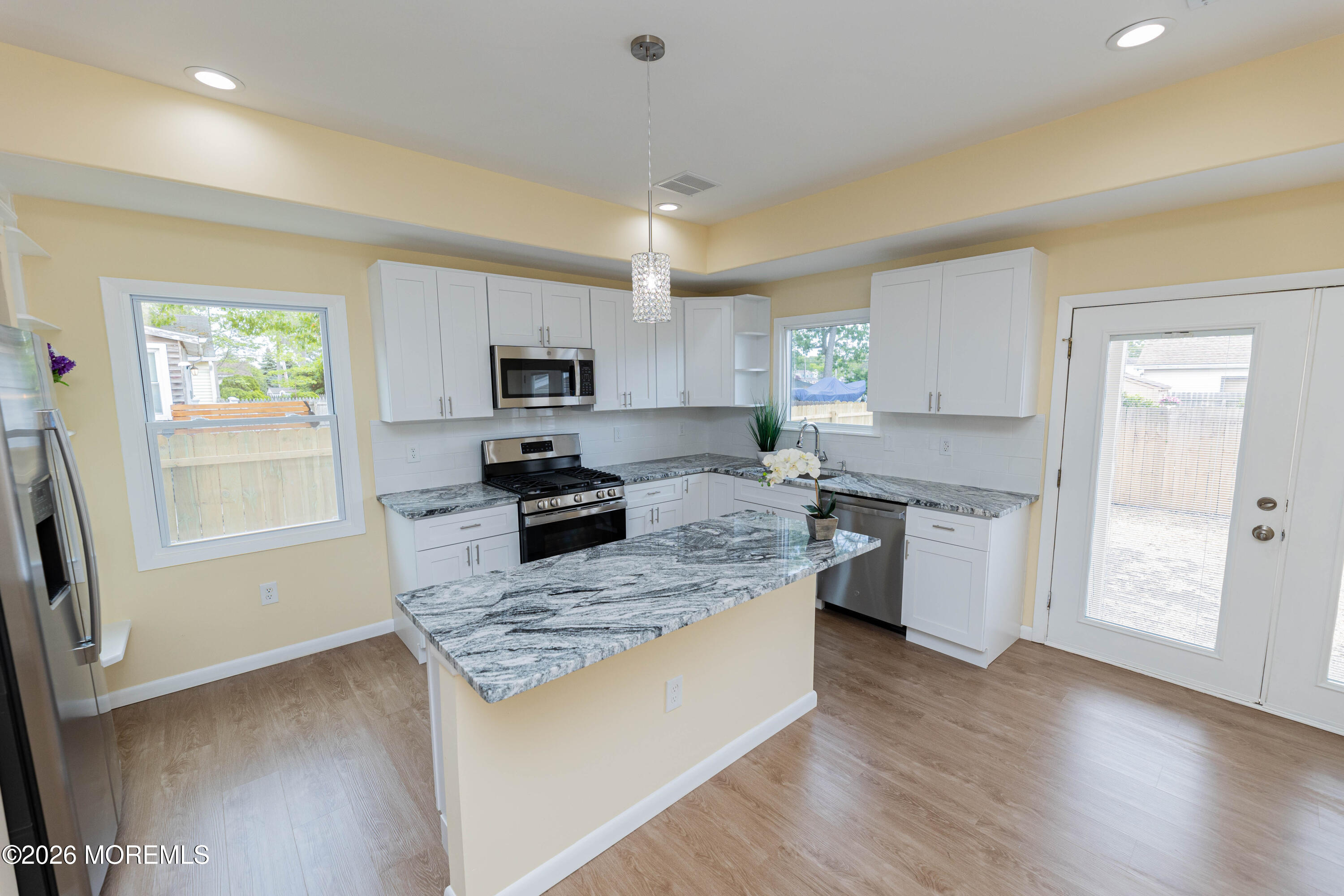 2408 Herbertsville Road Point Pleasant, NJ 08742 - Photo 10 of 82 a kitchen with granite countertop a stove top oven a sink dishwasher and a refrigerator with wooden floor
