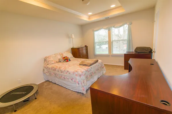 a bedroom with a bed and a large window