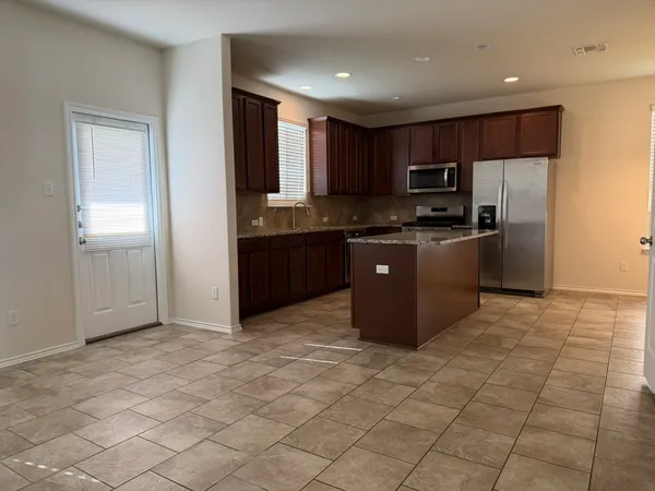 a kitchen with stainless steel appliances granite countertop a refrigerator and a stove top oven