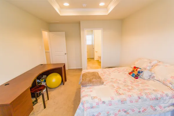 a bedroom with a bed a table and a dresser next to a window