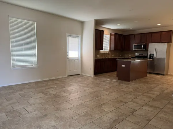 a kitchen with stainless steel appliances granite countertop a stove a sink a refrigerator a microwave a counter top and cabinets