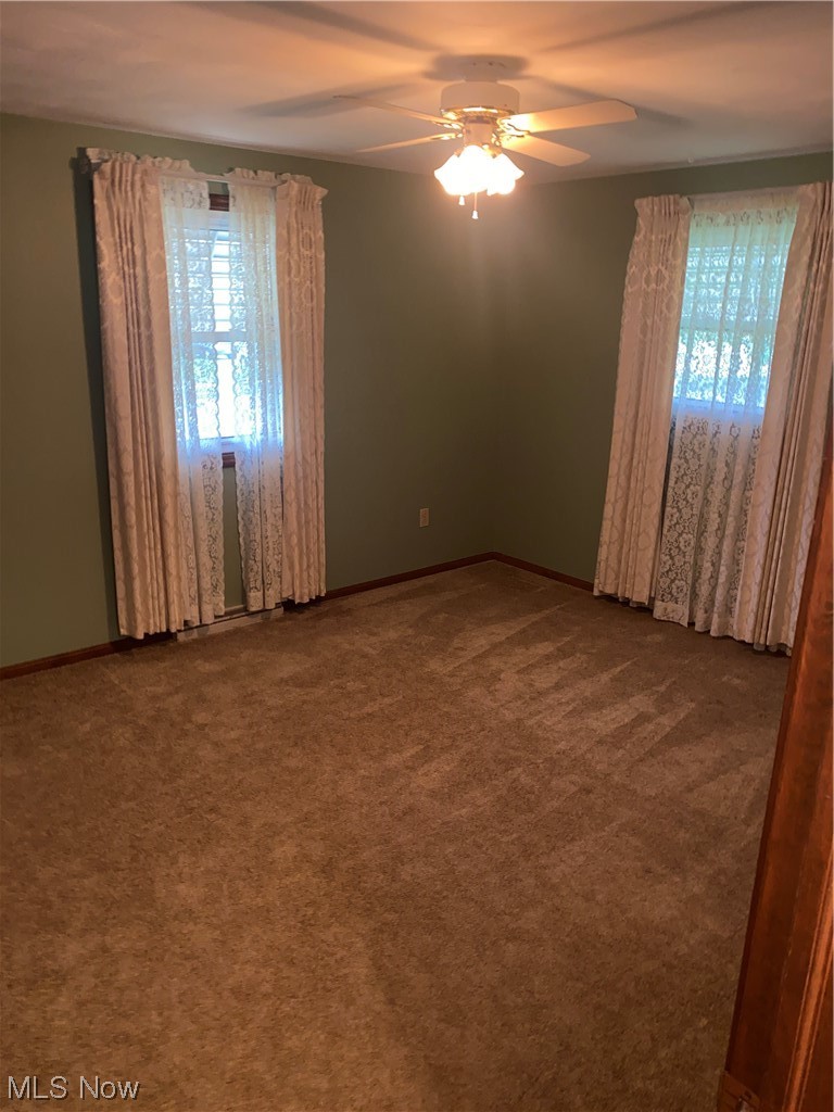 1518 Walnut Road Southwest Massillon, OH 44647 - Photo 8 of 26 Spare room featuring dark carpet and ceiling fan