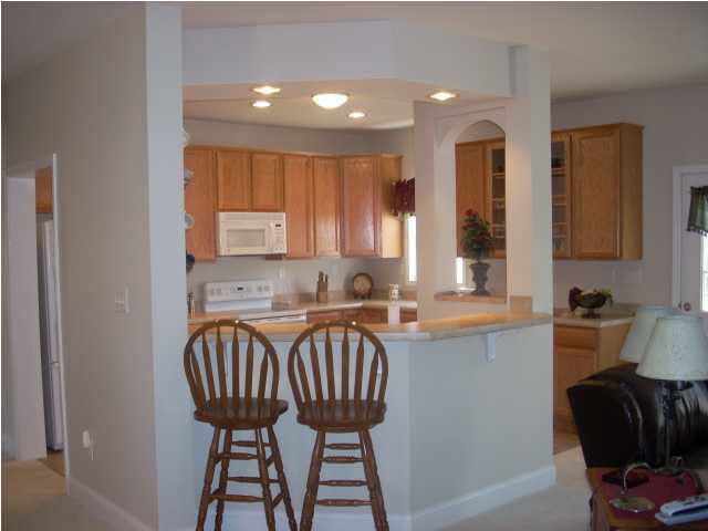 a kitchen with a sink a refrigerator and chairs
