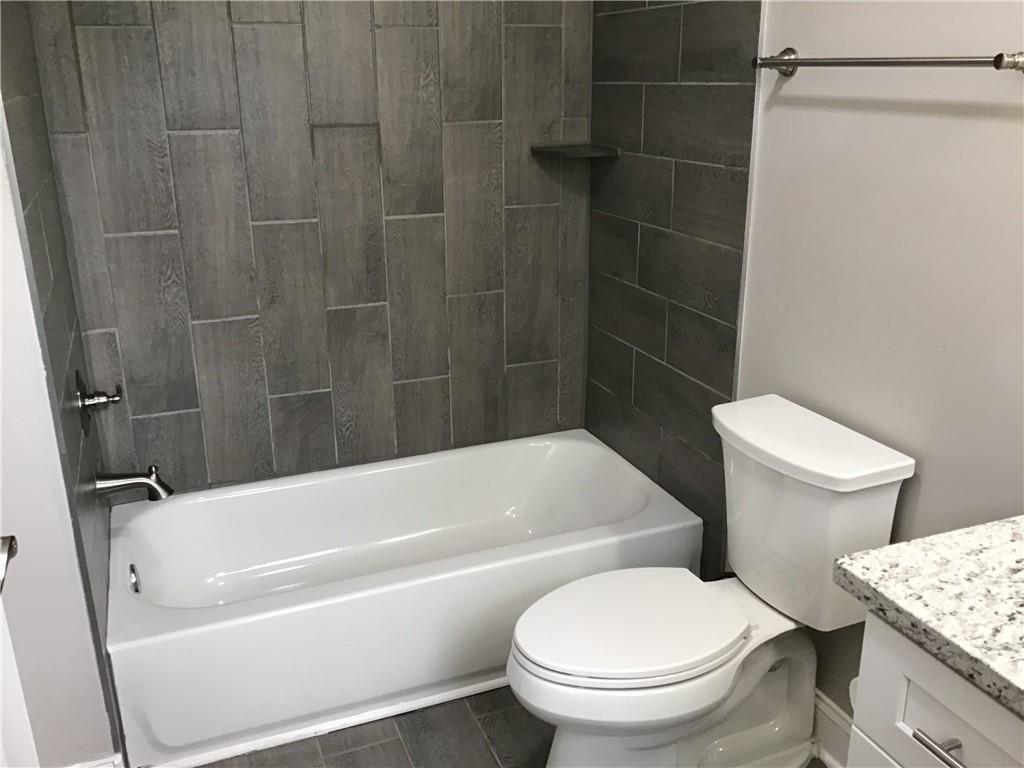 6184 Geiger Street Northwest Covington, GA 30014 - Photo 11 of 16 a white toilet and tub sitting next to a bathroom sink