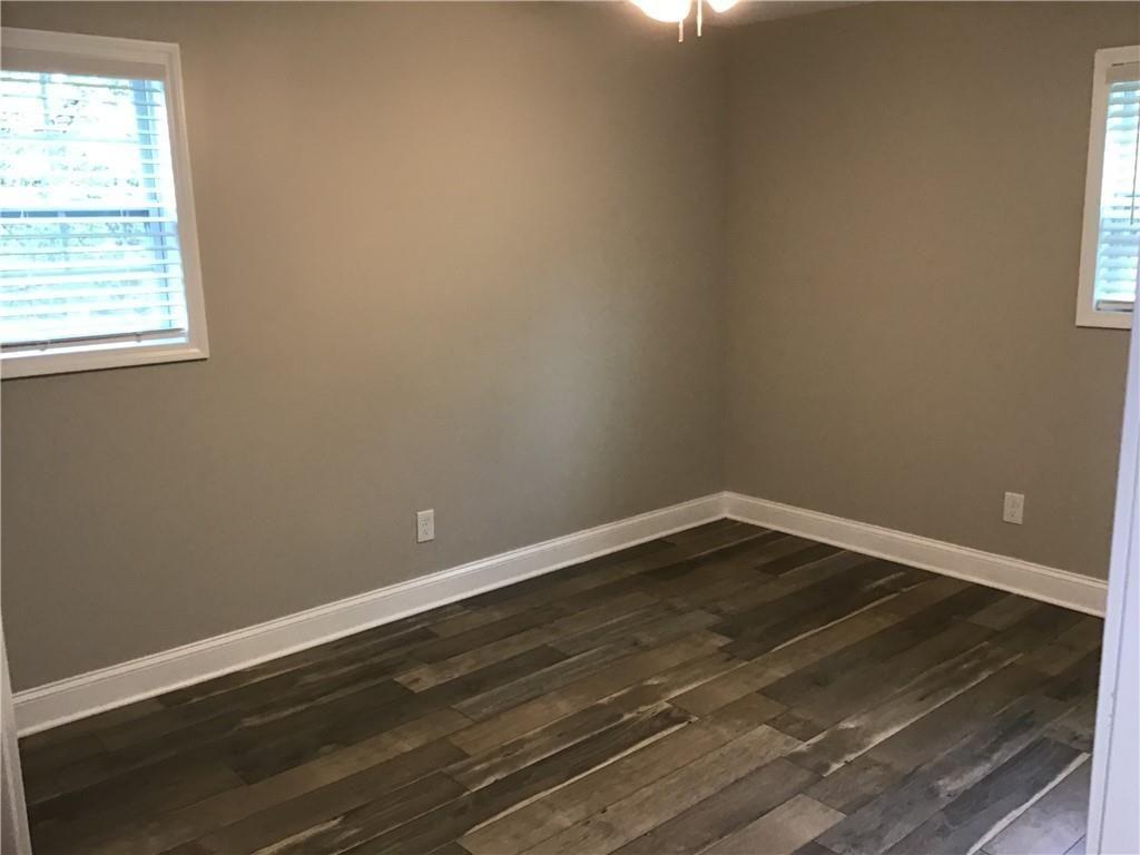 6184 Geiger Street Northwest Covington, GA 30014 - Photo 13 of 16 a view of an empty room with wooden floor and a window