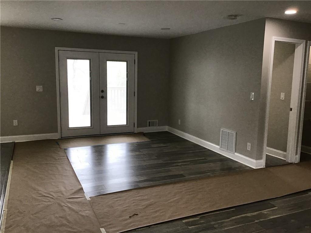 6184 Geiger Street Northwest Covington, GA 30014 - Photo 5 of 16 an empty room with wooden floor and windows