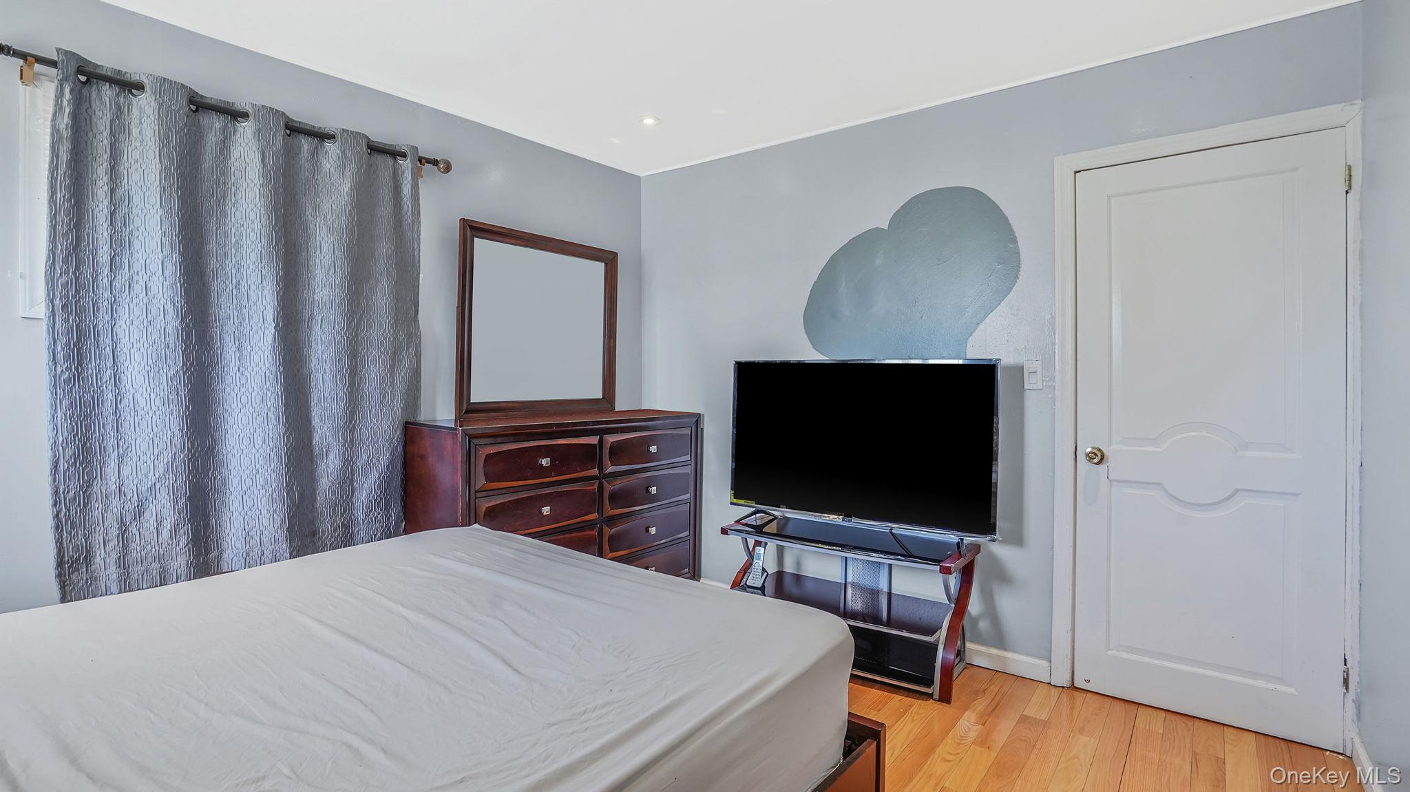 22 North Somerset Road Amityville, NY 11701 - Photo 22 of 25 a bedroom with a bed and a flat screen tv
