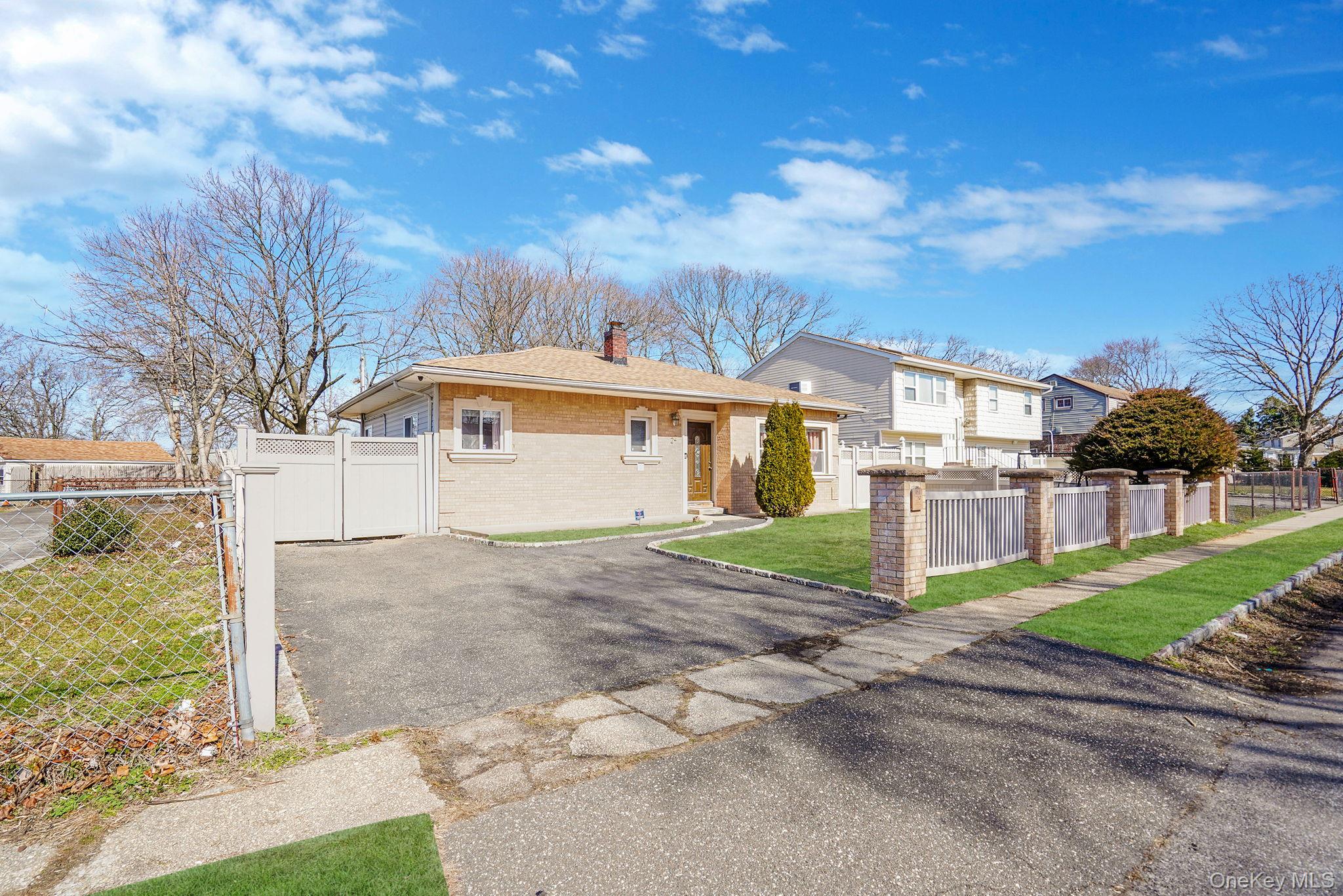 22 North Somerset Road Amityville, NY 11701 - Photo 3 of 25 a front view of a house with a yard and garage