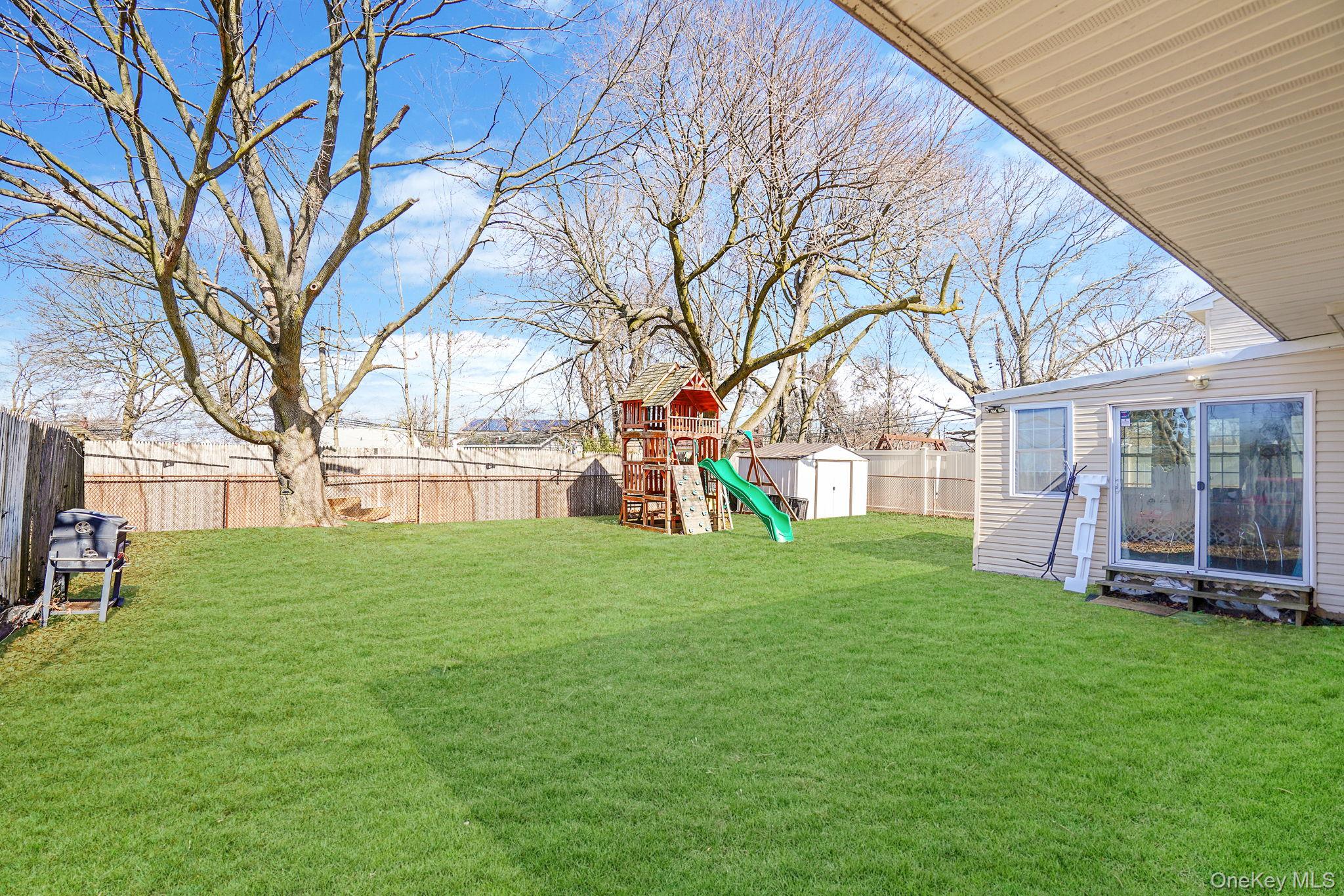 22 North Somerset Road Amityville, NY 11701 - Photo 6 of 25 a view of a house with a big yard and large trees