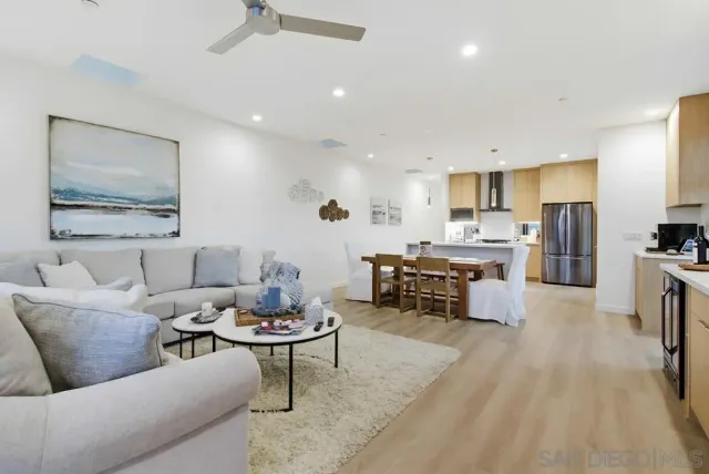 a kitchen with a sink a refrigerator a counter and chairs