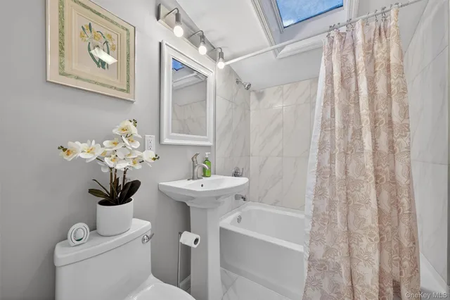 a bathroom with a sink a toilet and a shower curtain