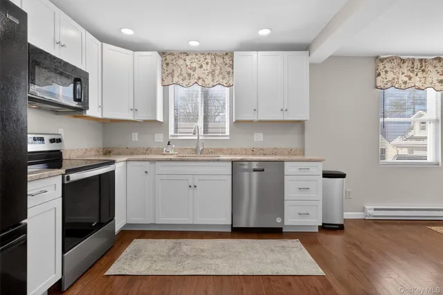 a kitchen with granite countertop a sink stainless steel appliances and cabinets
