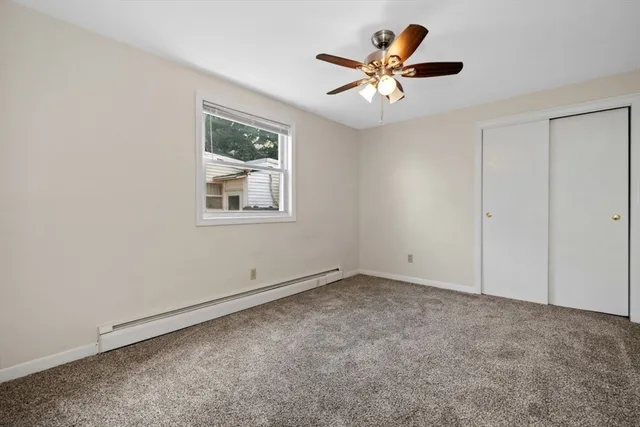 an empty room with a chandelier fan and windows