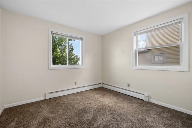a view of an empty room with closet and a window