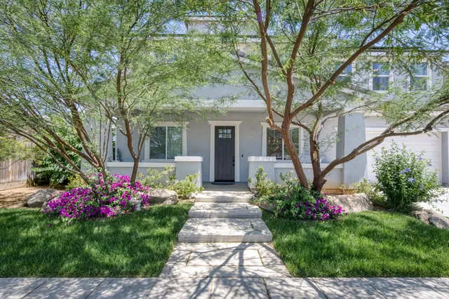 a front view of a house with a yard and fountain