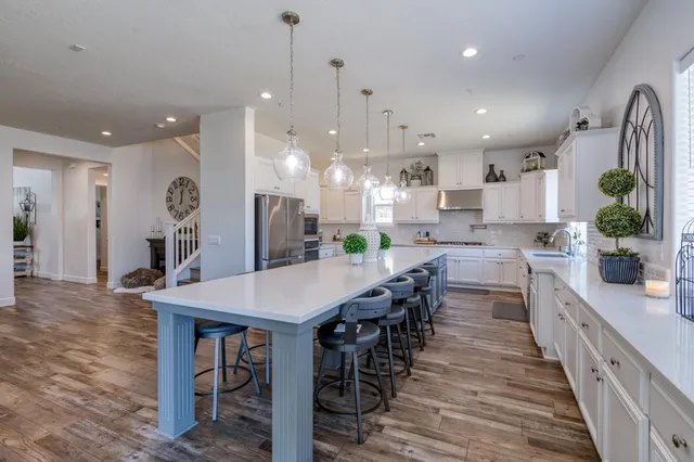 a large kitchen with cabinets table and chairs