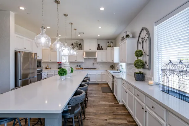 a large kitchen with stainless steel appliances a large center island attached withe living room