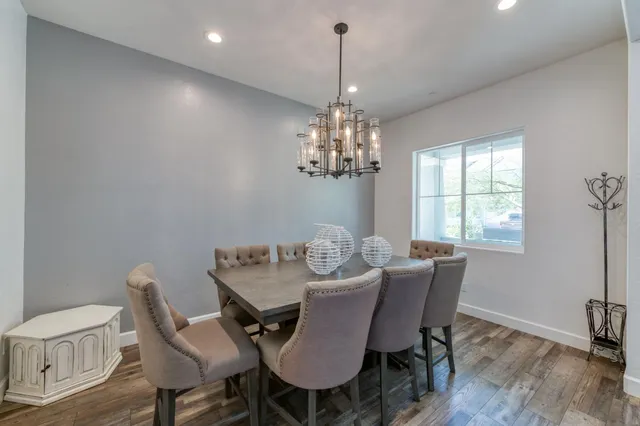 a view of a dining room with furniture a chandelier and wooden floor