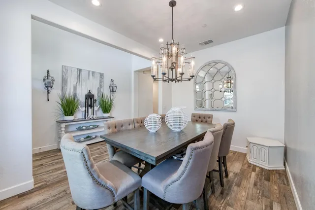 a view of a dining room with furniture a chandelier and wooden floor
