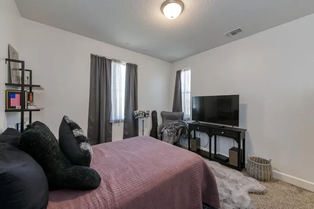 a bedroom with a bed and a flat screen tv