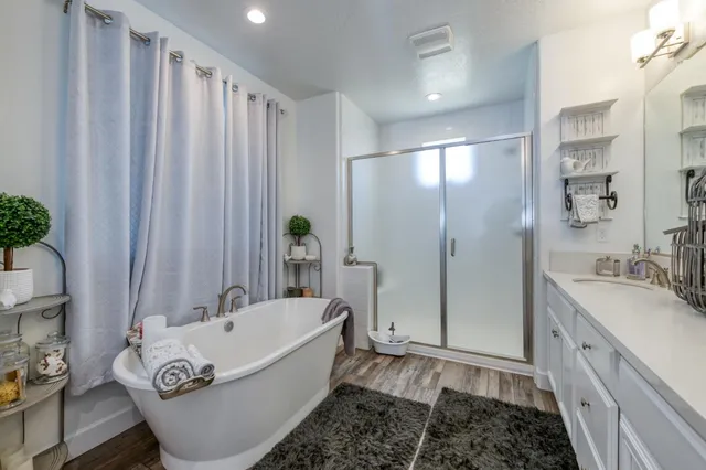 a bathroom with a tub sink and mirror
