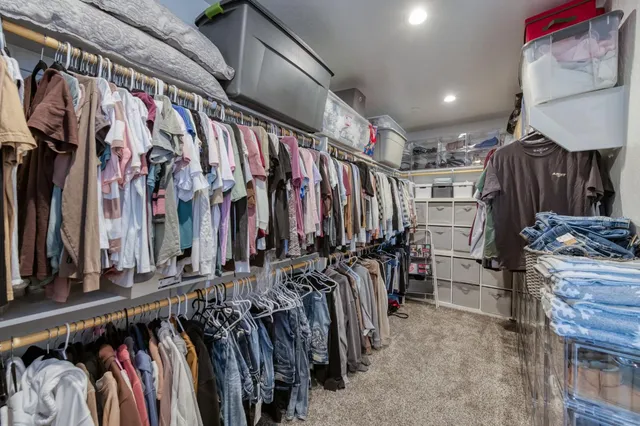a view of walk in closet with clothes