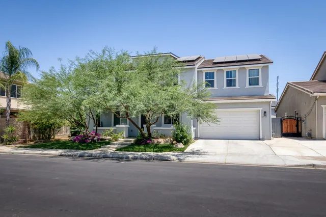 a tall yellow building with trees in front of it