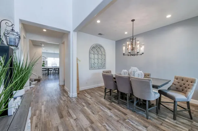 a view of a dining room with furniture a chandelier and wooden floor