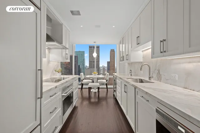 a large white kitchen with stainless steel appliances and white cabinets