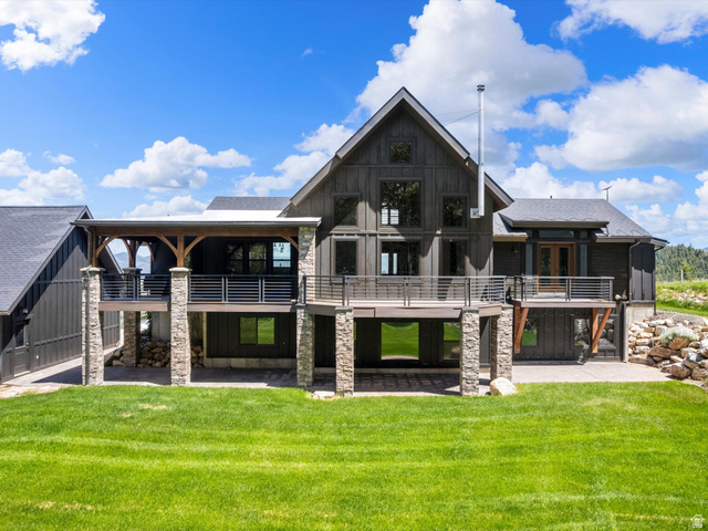 1225 Old Oregon Road Soda Springs, ID 83276 - Photo 59 of 67 Contemporary residence featuring dark vertical siding, multiple balconies with cable railings, and stone-clad support pillars