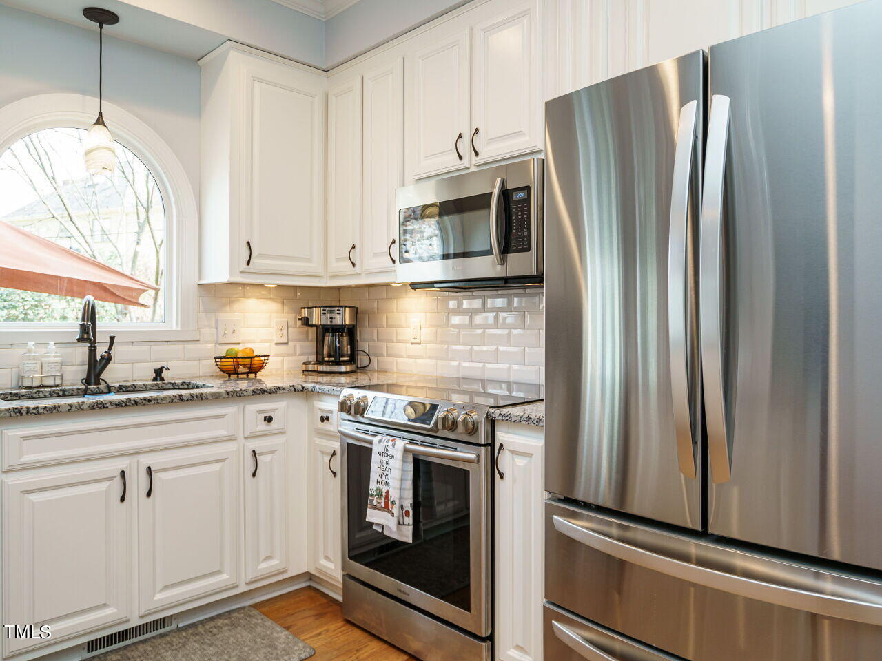 220 Custer Trail Cary, NC 27513 - Photo 12 of 31 a kitchen with white cabinets and stainless steel appliances