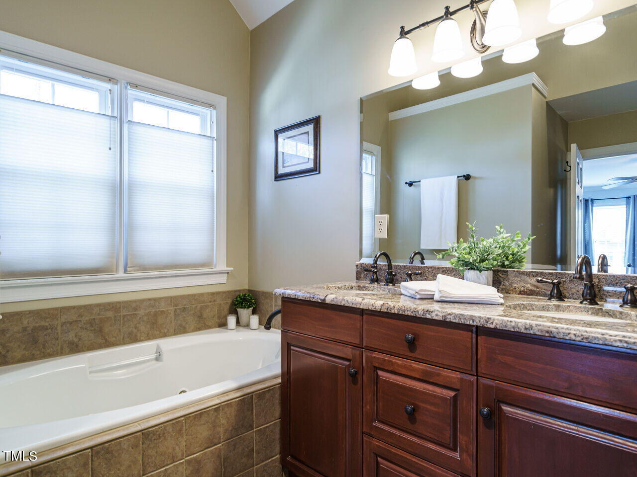 220 Custer Trail Cary, NC 27513 - Photo 17 of 31 a bathroom with a granite countertop sink mirror and a bathtub
