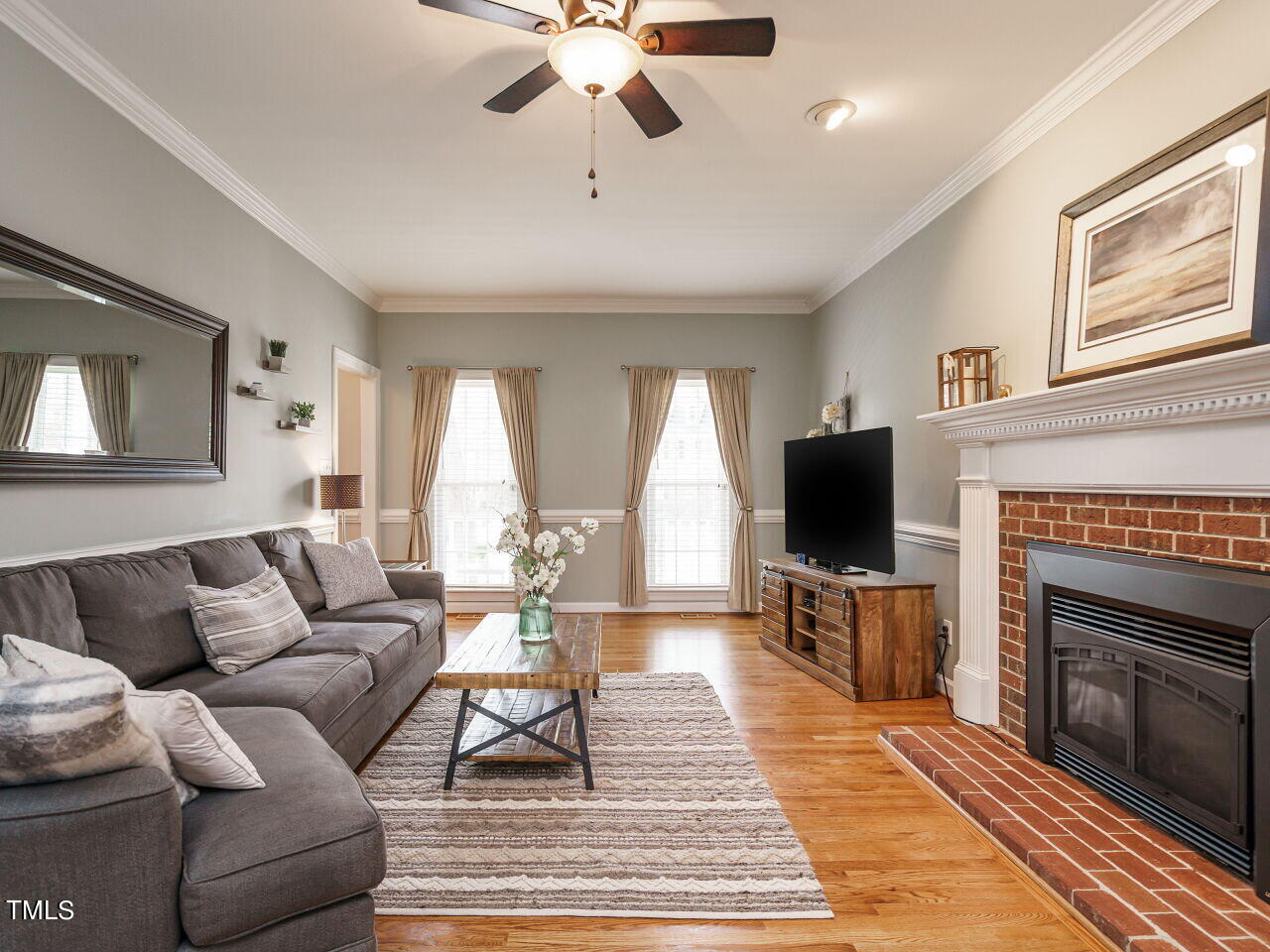 220 Custer Trail Cary, NC 27513 - Photo 3 of 31 a living room with furniture a flat screen tv and a fireplace