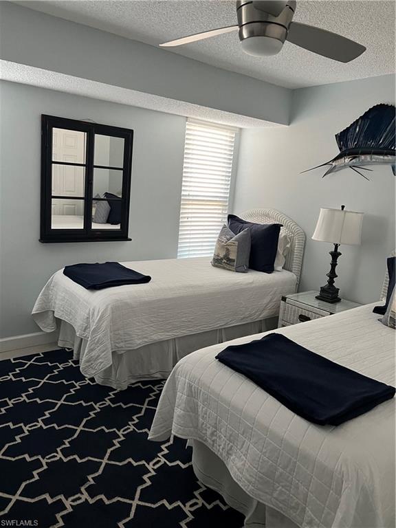 671 100th Avenue North Naples, FL 34108 - Photo 13 of 16 Bedroom with ceiling fan, a textured ceiling, and carpet floors