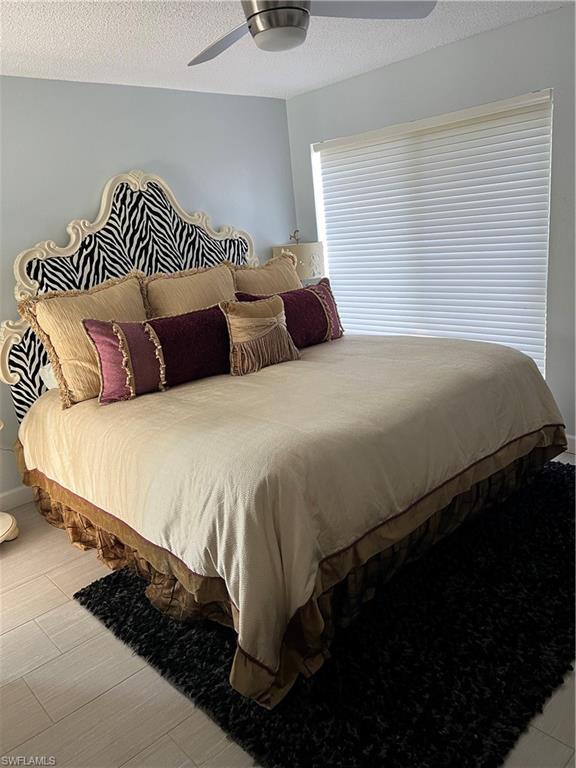 671 100th Avenue North Naples, FL 34108 - Photo 9 of 16 Bedroom with ceiling fan and a textured ceiling