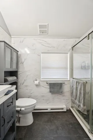 a bathroom with a granite countertop sink mirror vanity and toilet