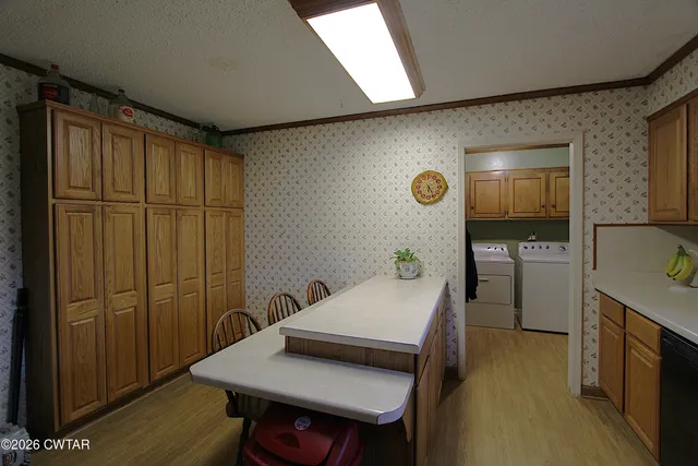 a kitchen with stainless steel appliances kitchen island granite countertop a refrigerator a sink dishwasher a stove with wooden cabinets and a granite counter top