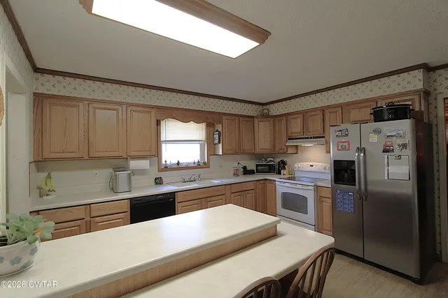 a kitchen with a refrigerator a sink and cabinets