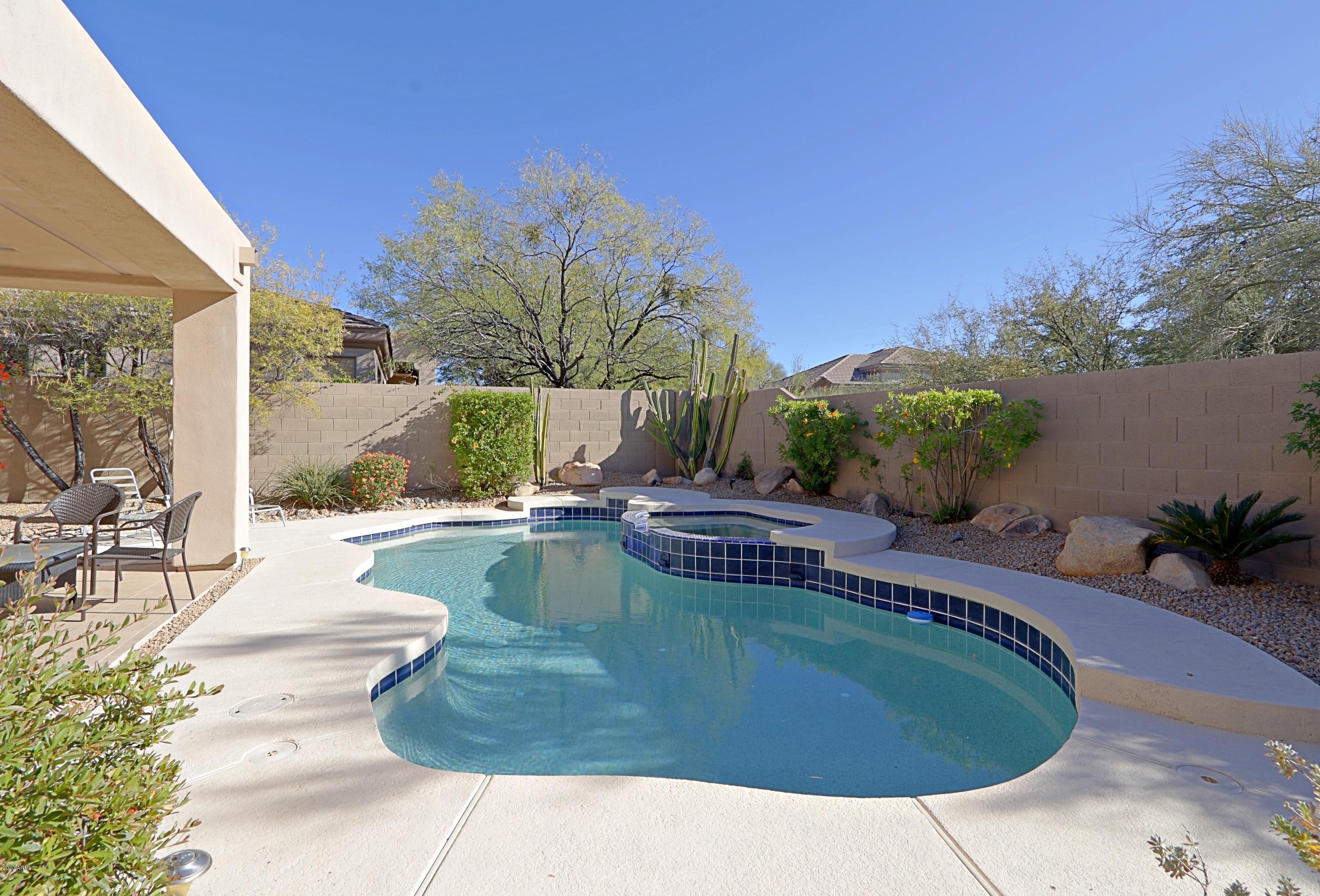 6803 East Eagle Feather Road Scottsdale, AZ 85266 - Photo 32 of 67 a view of a swimming pool with outdoor seating and plants