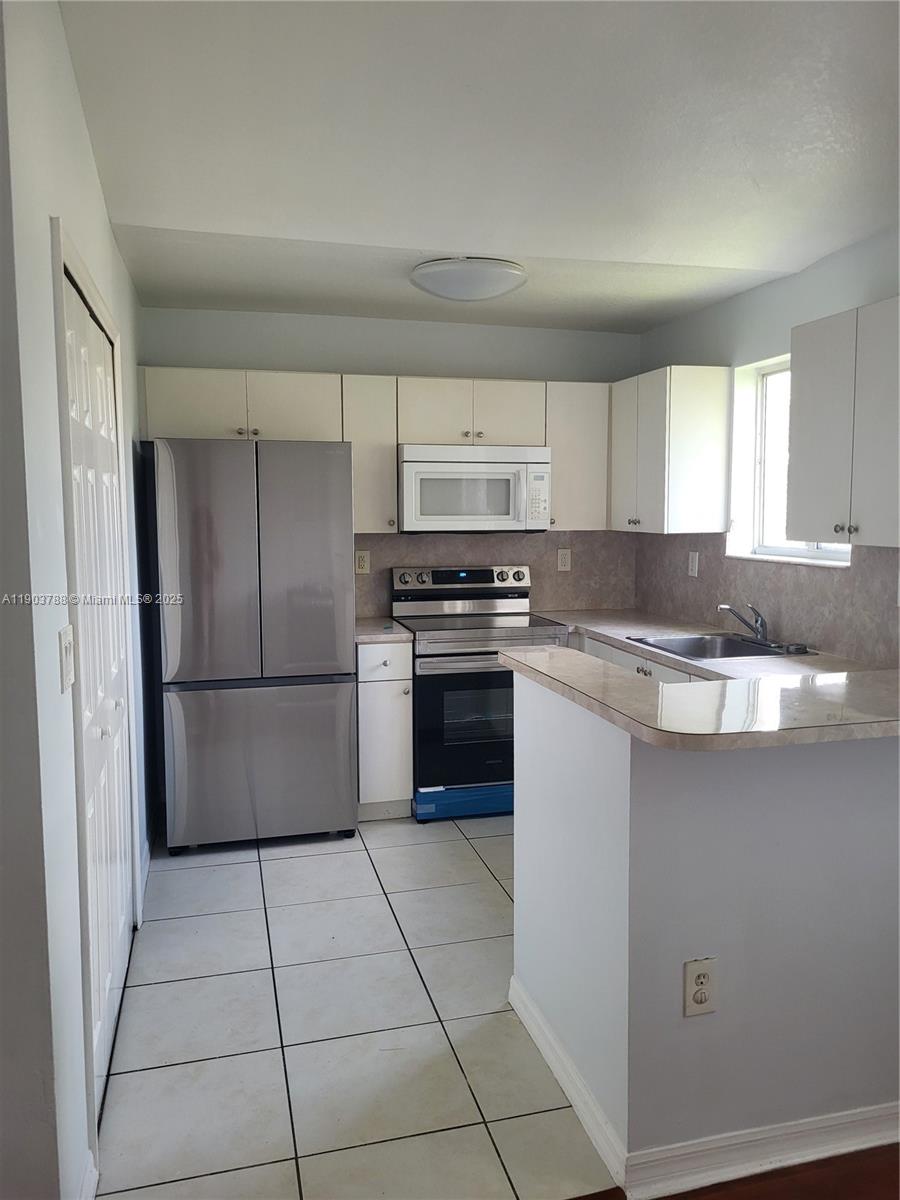 2920 Southeast 12th Road, Unit 20130 Homestead, FL 33035 - Photo 2 of 11 a kitchen with granite countertop a refrigerator and a sink