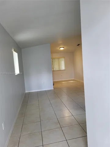a view of a livingroom with an empty space and a window