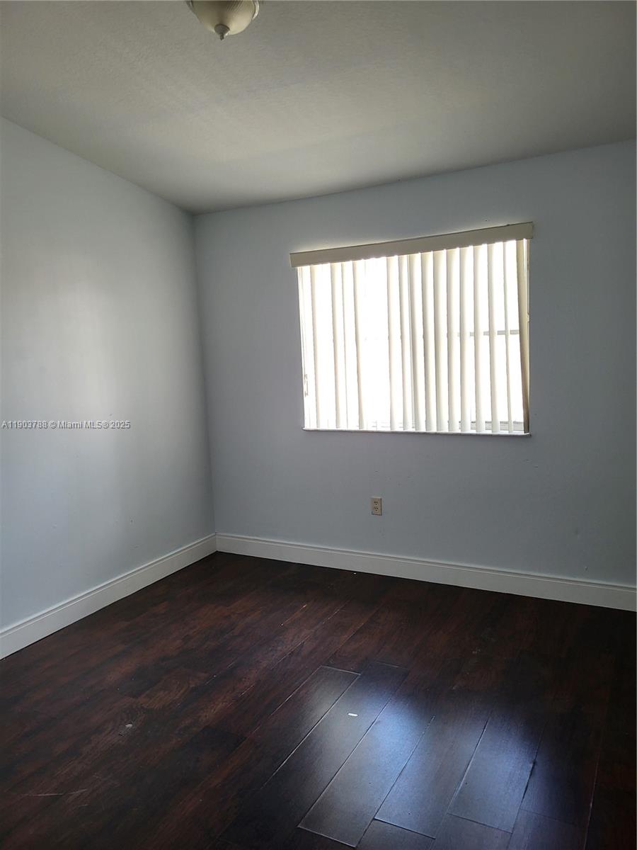 2920 Southeast 12th Road, Unit 20130 Homestead, FL 33035 - Photo 5 of 11 an empty room with wooden floor and windows